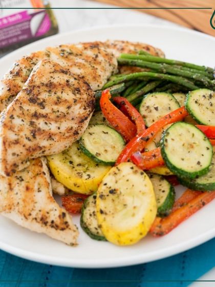 A plate of grilled chicken served with colorful roasted vegetables. This simple, clean meal is perfect for anyone looking for a high-protein, low-carb dinner option.