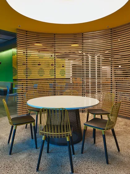 A semi-private meeting area created with curved wooden slat screens. The design provides a sense of enclosure without completely closing off the space.