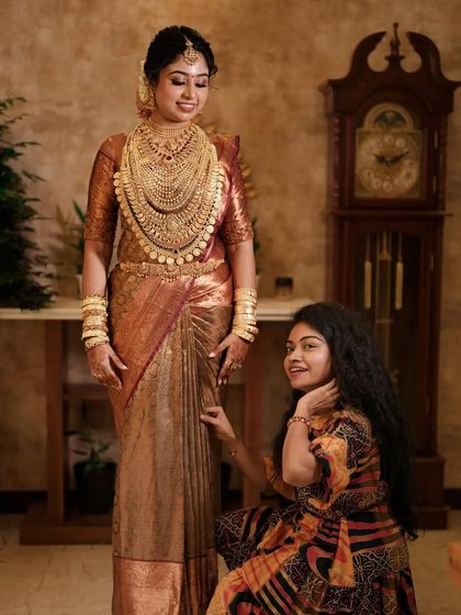 I love my job! A candid moment of me with a happy bride, admiring the perfect drape of her antique gold silk saree.