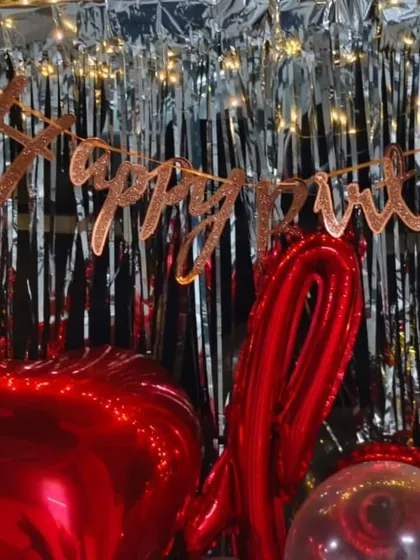 A close-up of the romantic car boot decor, showing the 'Happy Birthday' banner and red foil balloons. It's a quick, easy, and impactful surprise we can set up in minutes.