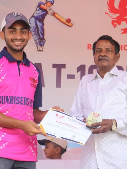 A smiling player from Sunrisers RCA receives his certificate and medal.