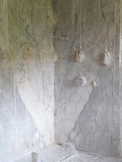 The master bathroom is taking shape. Here, large slabs of Satuario stone are being installed on the walls. Even covered in construction dust, the luxury and beauty of the marble are undeniable.