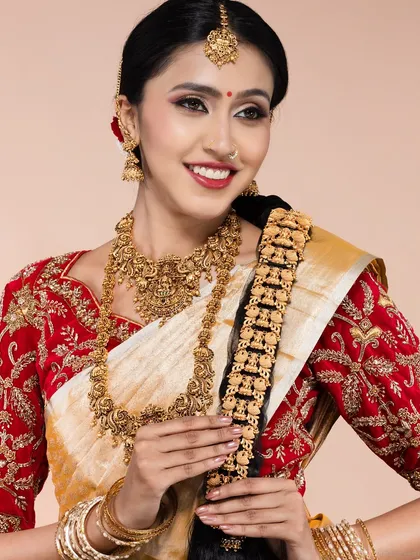 A smiling model in a traditional South Indian bridal look, featuring a red embroidered blouse, white and gold saree, and elaborate temple jewellery. This shot shows my versatility in capturing classic ethnic beauty for bridal portfolios and lookbooks.