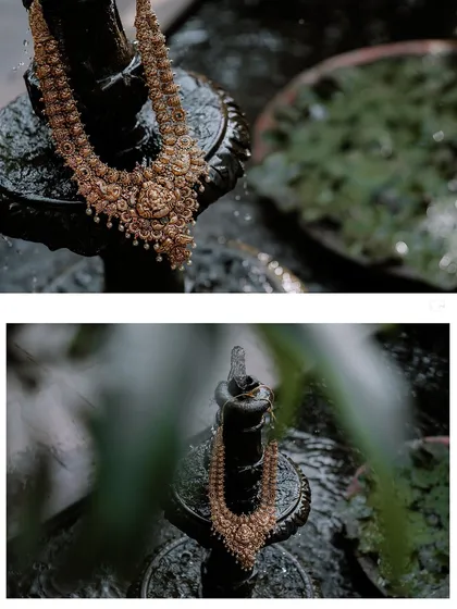 A creative shot of a traditional gold necklace displayed on a wet, stone sculpture.