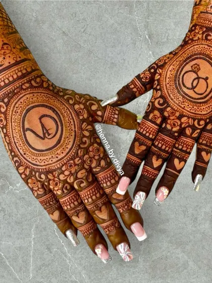 A beautiful back-hand design for an engagement, featuring the couple's monogram 'VD' and an engagement ring symbol. The design is filled with hearts and floral details for a romantic feel.