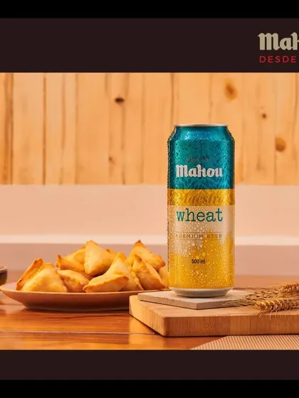 A classic pairing of Mahou Wheat beer with hot samosas. This image uses strategic lighting and styling to make a simple snack feel like an irresistible treat, perfect for advertising and social media.