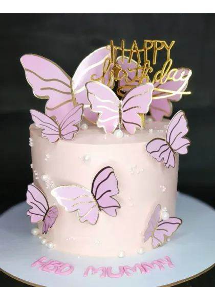 An elegant pink butterfly cake for a mother's birthday. This is a mixed fruit flavor with fresh whipped cream, decorated with delicate pink and gold butterflies.
