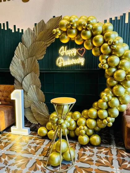 Celebrating a first anniversary in style. I designed this chic, all-gold balloon ring backdrop with a 'Happy Anniversary' neon sign and a light-up number '1'. The setup is modern, elegant, and creates a perfect photo opportunity for the couple.
