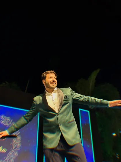 Arms wide open, embracing the celebration. This pose captures the grand, larger-than-life feel of the Sangeet nights I host.
