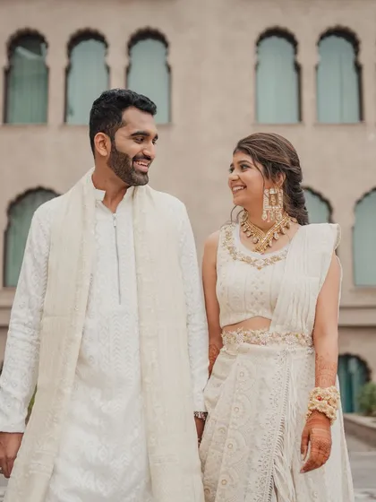 The couple looking radiant in their coordinated white outfits, a perfect choice for a day event at the beautiful Fairmont Jaipur.