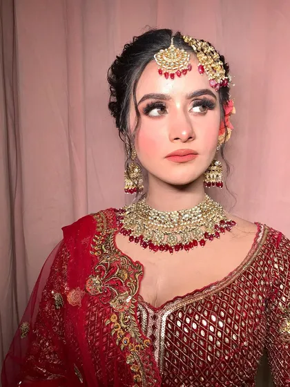 A side profile, showing the intricate details of her mathapatti and the floral arrangement in her hair.
