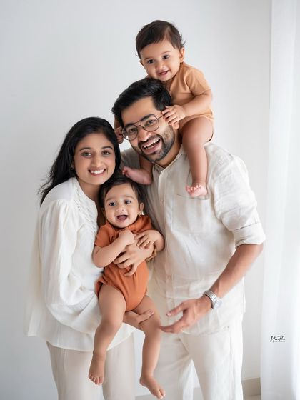 A classic family portrait with two young children, full of smiles.