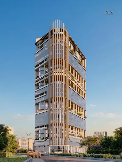 A perspective of the Narmada commercial tower. The design features a curved facade with vertical fins, creating a dynamic and elegant structure that serves as a hub for showrooms, restaurants, and offices.