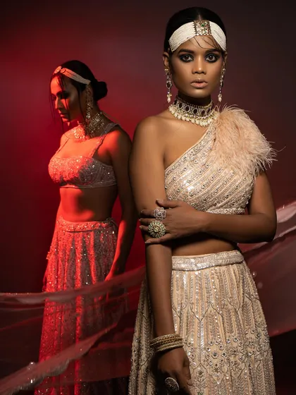 An editorial look with a high-fashion bridal feel. I styled this one-shoulder embellished blouse and lehenga with a feather detail and dramatic makeup to create a bold, avant-garde statement.