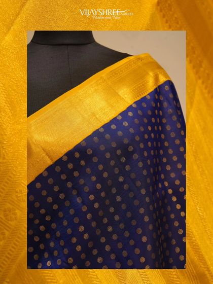 A close-up of the gold polka dots against the rich blue silk.