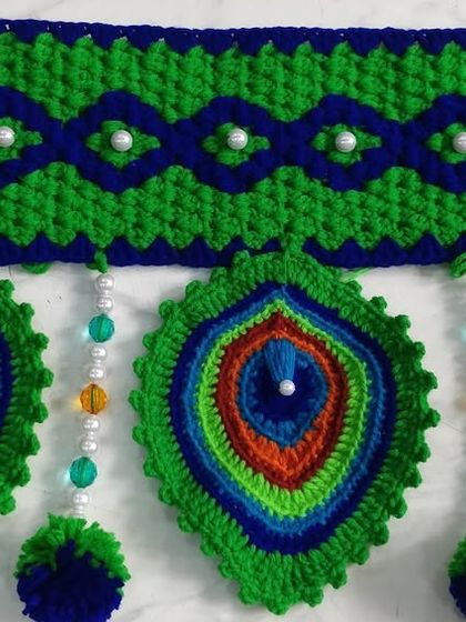 A close up of the peacock feather motif with colorful bead details, showing the intricate color work.