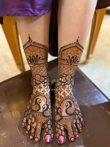 Don't forget the feet! This symmetrical peacock design is one of my favorites, creating a stunning effect that looks like beautiful payals. The combination of bold figures and delicate patterns ensures your bridal look is perfect from head to toe.