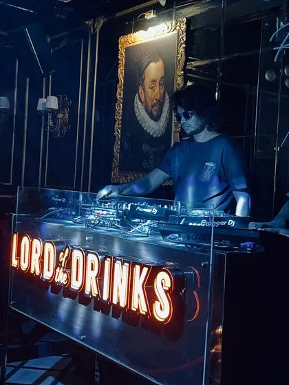 A cool, blue-lit shot of me focused on the mix at the iconic Lord of the Drinks console.