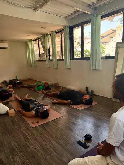 A co-teacher guides students into Savasana (Corpse Pose) at the end of our workshop. This final rest is essential for integrating the benefits of the practice.