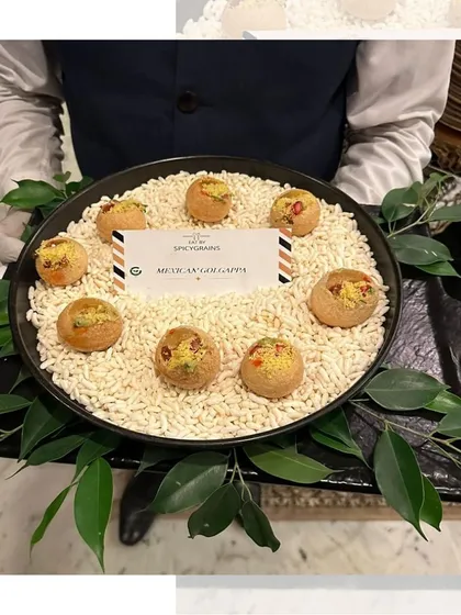 Our Mexican Golgappa, elegantly presented on a bed of puffed rice. This fusion snack is a flavor explosion, combining the best of Indian and Mexican cuisines.