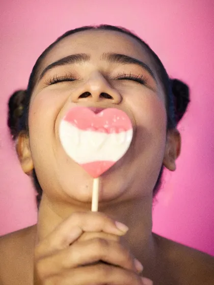 A sweet and happy moment with a heart lollipop. This showcases a youthful and innocent vibe suitable for a variety of commercial print projects.