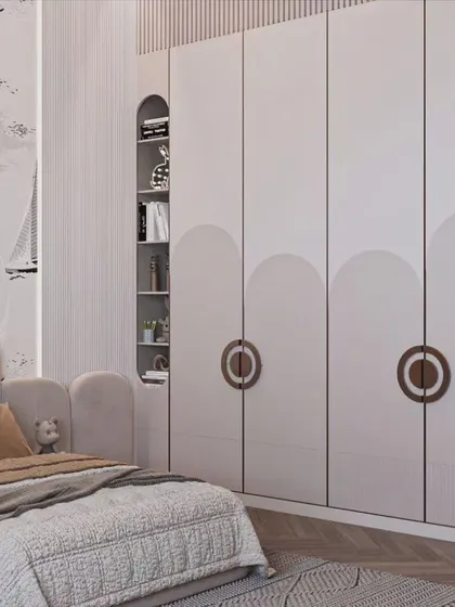 A charming nautical-themed kids' room. The wardrobe features unique circular handles and is flanked by open shelving, while the wallpaper and decor complete the seafaring adventure theme.