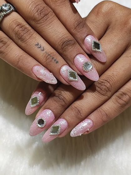 A full look at these gorgeous Navratri nails. The combination of a glittery pink base and mirror-like gems creates a look that’s as festive and dazzling as the celebration itself.