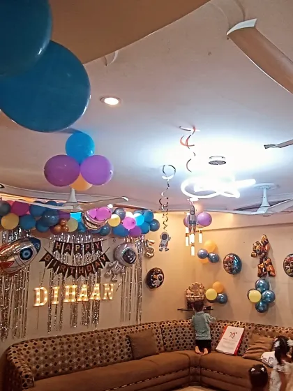 A wider view of the living room transformed for a space party. I use ceiling decor, wall props, and a main backdrop to create an immersive experience even in a smaller space.