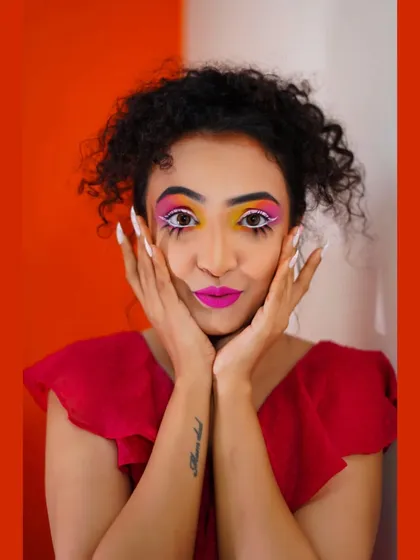 A playful pose from the color photography shoot, with a dramatic white lower lash line effect.