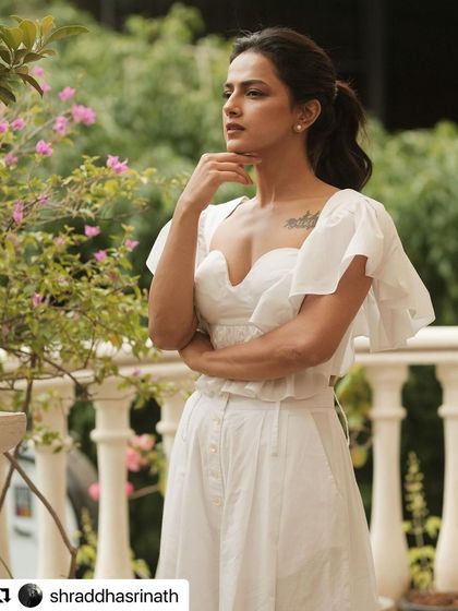 A three-quarter view of the white ensemble styled for Shraddha Srinath, showing how the pieces create a flattering and graceful silhouette.