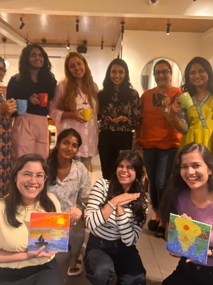 A large group of women smiling after a paint and sip event. It's a perfect way to unwind, create, and socialize.
