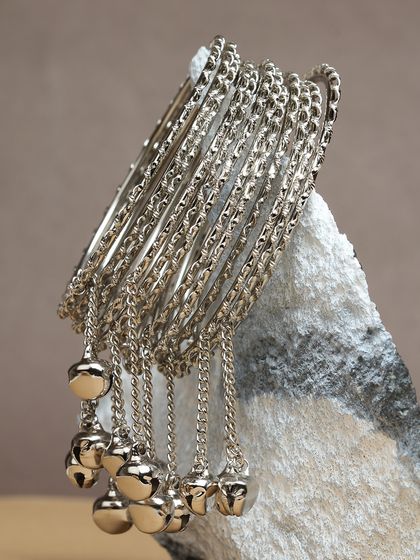 A set of silver-toned bangles with dangling jhumki charms.