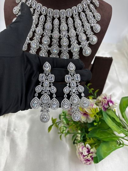 A magnificent, full-coverage AD necklace set designed for grand events. The intricate web of American Diamonds creates a dazzling effect, perfect for bridal and reception wear.