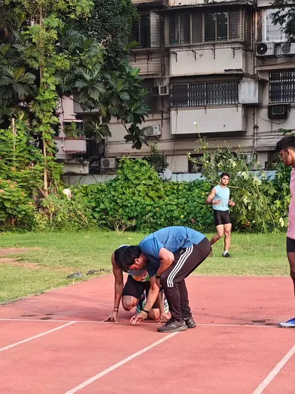Technique is everything. I am hands-on with every athlete, like in this photo where I'm correcting the starting position to ensure maximum power and efficiency off the line. Every detail matters.