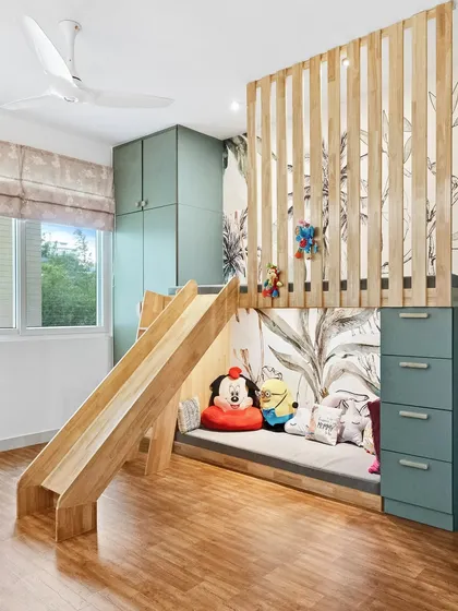 A full view of the kid's room with the loft bed and slide, demonstrating a perfect balance of fun and function. The design transforms a simple bedroom into a personal playground.