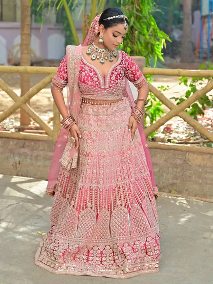 A full-length shot of the bride in her pink and green lehenga, looking absolutely radiant.