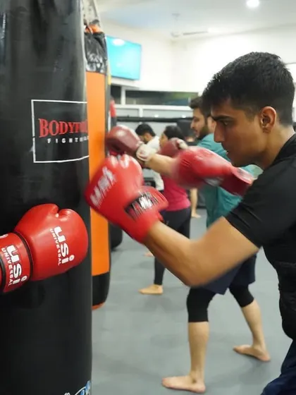 A student works on power and technique on the heavy bag. This is a crucial tool for developing knockout power and cardiovascular endurance.