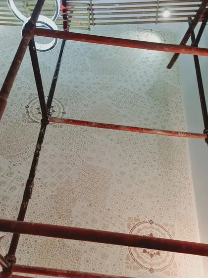 An upward view of the scaffolding and the ceiling during a decorative painting project. This demonstrates the scale of work we can undertake for large villas and independent houses with double-height areas.
