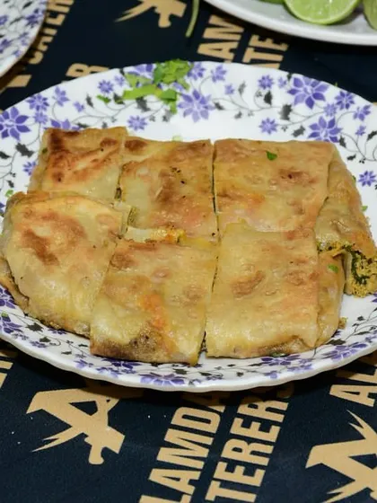 A freshly made Baida Roti, perfectly cooked and cut into four pieces. It is a filling and delicious option for your Iftar meal.