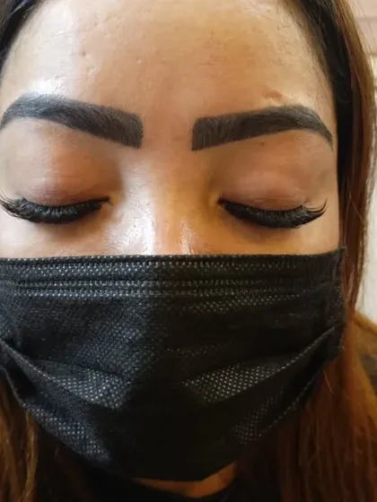 The same client with her eyes closed, showing the flawless application and texture of her wispy eyelash extensions. The lashes blend seamlessly for a natural yet enhanced look.