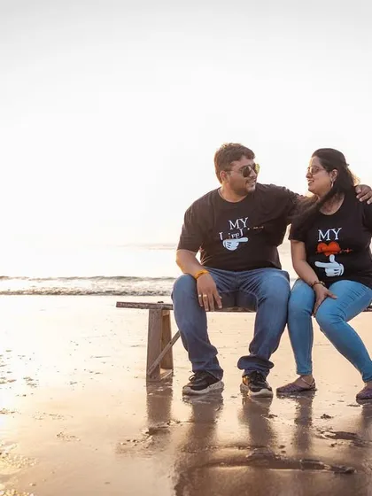 A casual and sweet moment on a beachside bench. The matching "My Better Half" t-shirts add a cute, personal touch to their pre-wedding shoot.
