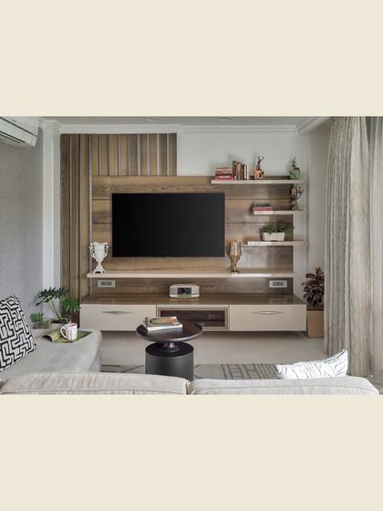 A classic and functional TV unit design. The combination of a fluted wood panel, off-white drawers, and open shelving provides a balanced mix of texture, storage, and display space.