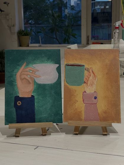 A creative diptych painting of two hands holding coffee cups, made by a couple during an art date. A perfect representation of creating together.