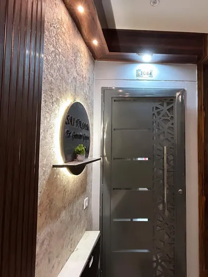 A close-up of the entrance, highlighting the details of the backlit nameplate and the rich textures of the wall panels.