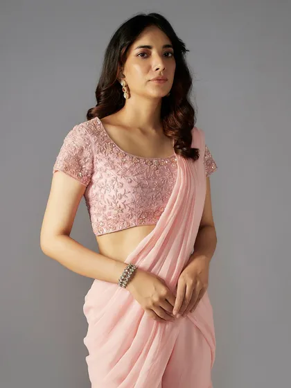A closer look at the embellished blouse of the pink sharara-saree, featuring delicate floral embroidery.