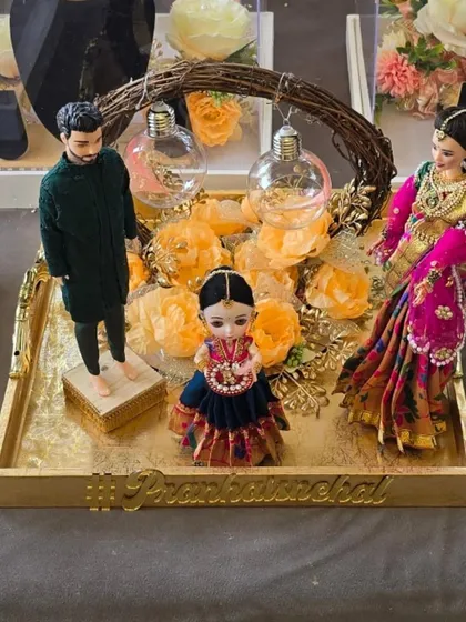 An exquisite engagement ring tray featuring custom dolls of the couple and their child, all personalized with their wedding hashtag.