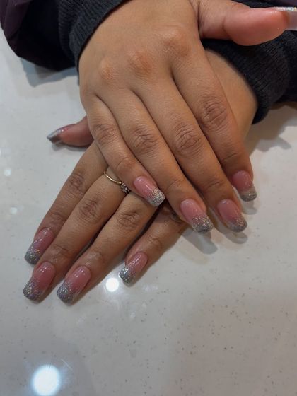 A closer look at our silver glitter French tip extensions. The square shape gives them a modern edge, while the glitter adds a touch of celebration.