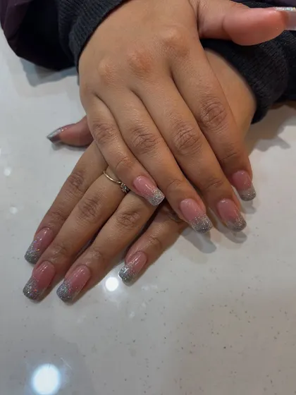 A closer look at our silver glitter French tip extensions. The square shape gives them a modern edge, while the glitter adds a touch of celebration.