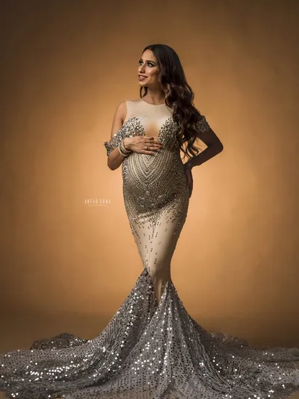 A confident and radiant pose in a show-stopping gown. The lighting is carefully placed to make the sequins sparkle and highlight the beautiful baby bump.