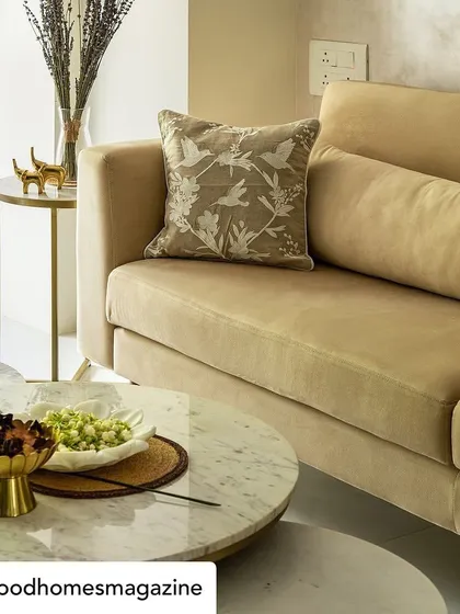 A close-up from the Good Homes feature on 'Calm Abode'. The soft beige sofa is accented with a beautifully embroidered cushion, showcasing our attention to detail in textiles and decor.